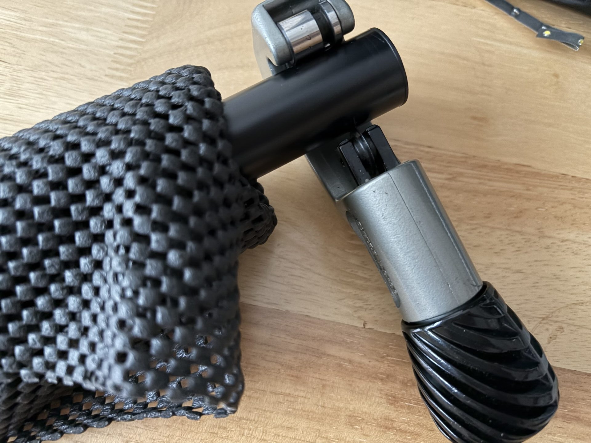 イクターパイプを専用カッターと100均の滑り止めシートで切断している様子