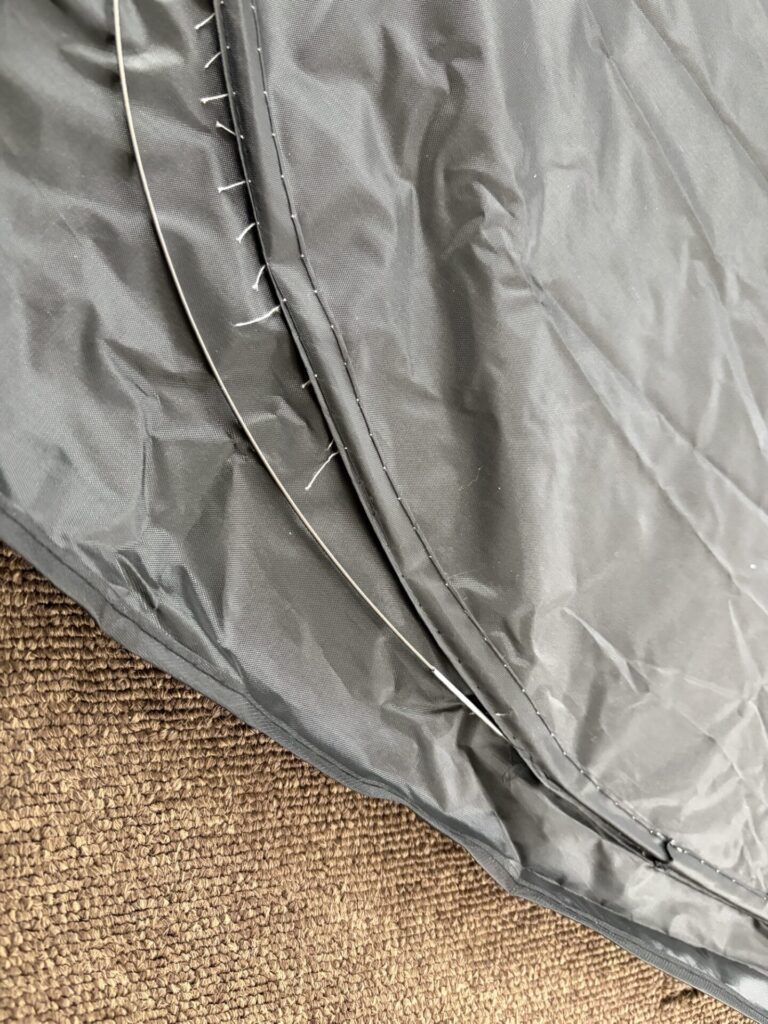 サンシェードの縁を切って、中に入っている針金(ワイヤー)を引き抜いている様子