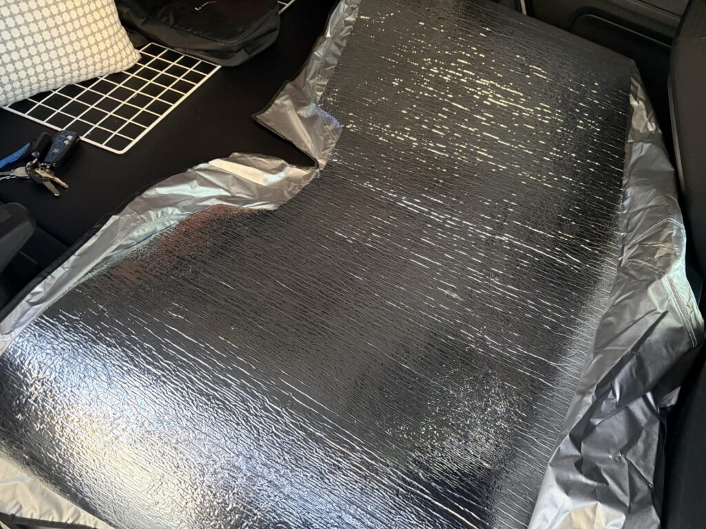 黒いサンシェード生地の上に、フロントガラスの形に切り出した銀マットを重ねている様子