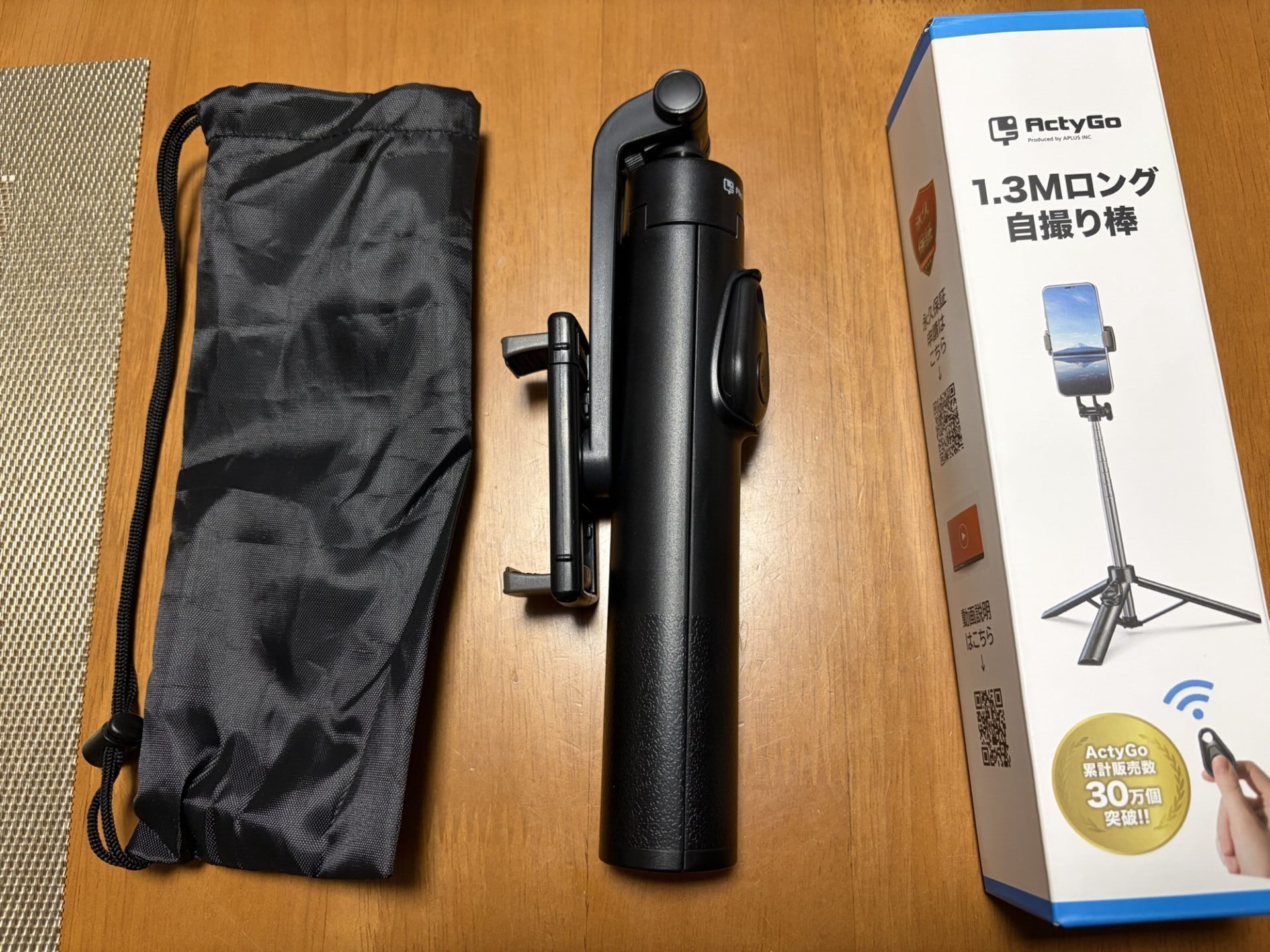 箱から取り出した自撮り棒本体（折りたたみ状態）と、付属の黒い収納袋