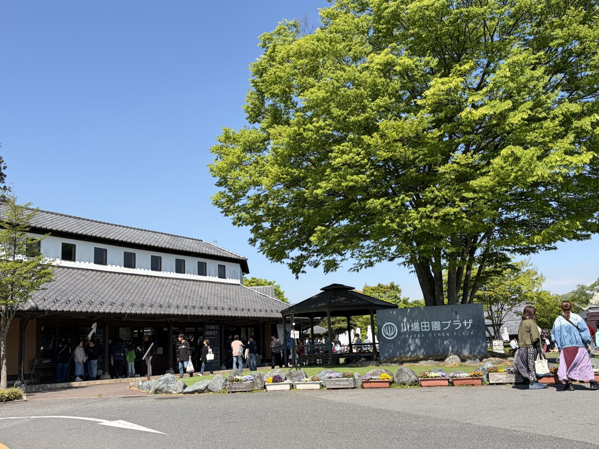 群馬県の大人気道の駅「川場田園プラザ」の看板と、緑豊かで趣のある建物の外観
