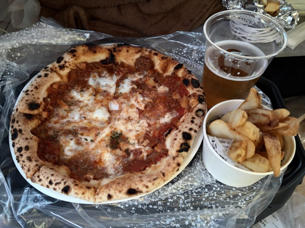 石窯ピザとビールが手作りテーブルの上に置かれています。