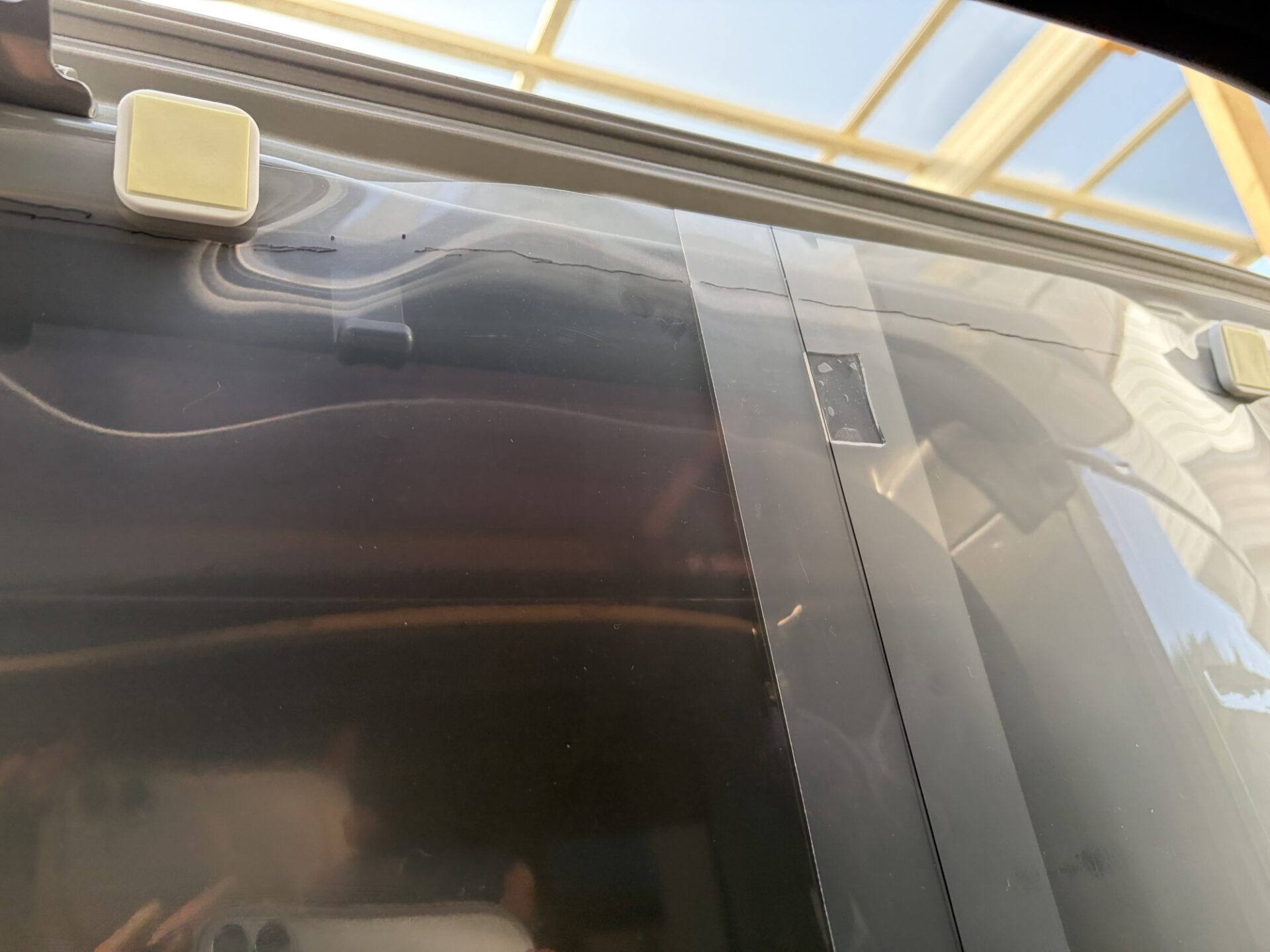 車のスライドドア枠にA3クリアファイルをマグネットで貼り付けて型取りをしている様子