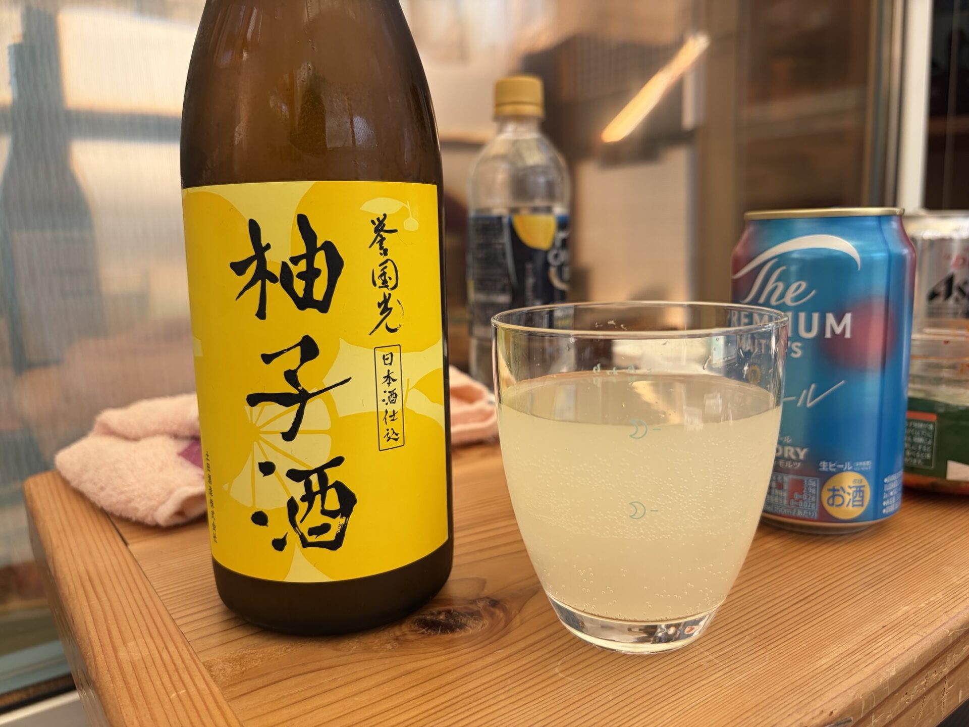 道の駅たぬまで購入した誉国光の日本酒仕込み柚子酒のボトルとグラスに注がれたお酒