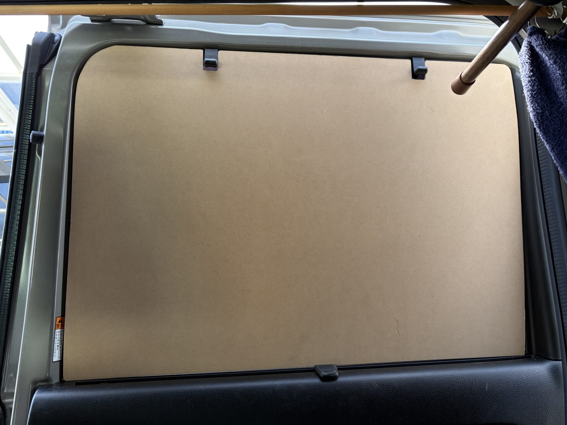 切り出した木製の網戸枠を車のスライドドアの内側に仮合わせしてぴったりハマっている様子