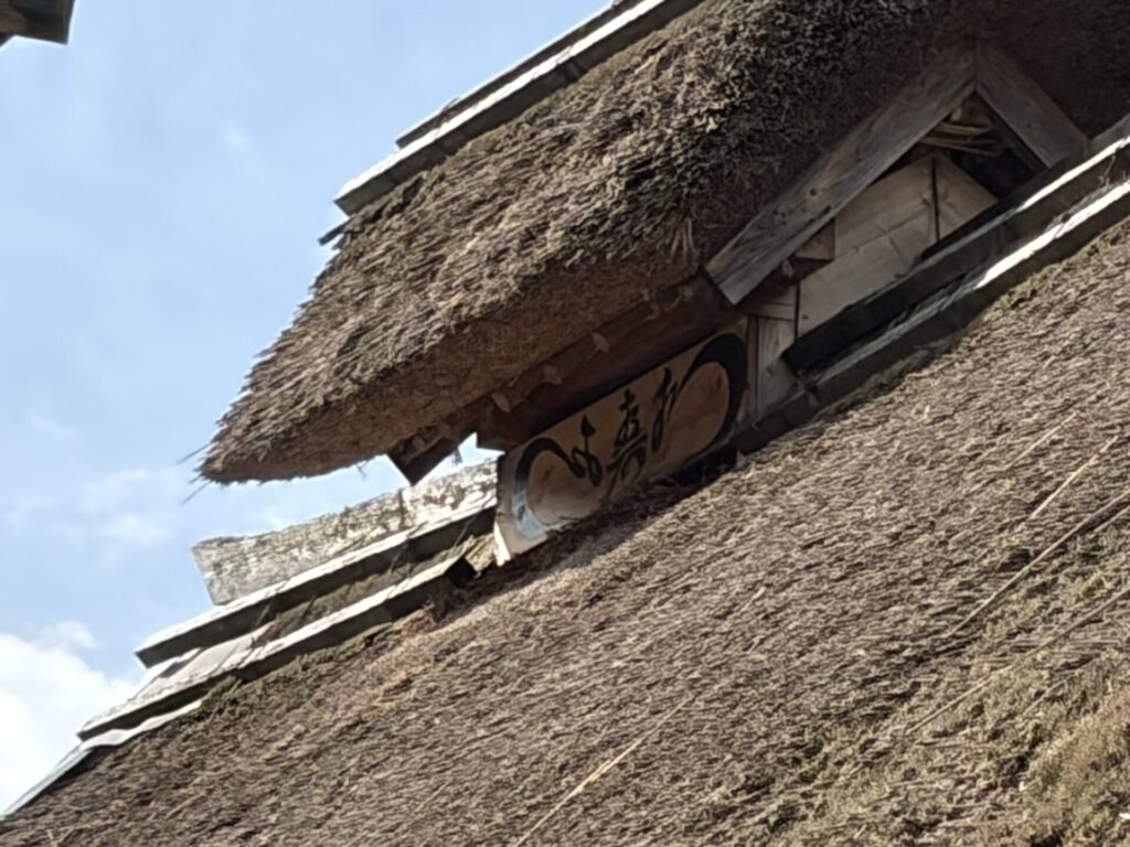 防火の願いを込めて「繁栄の寿」と「水」が書かれた茅葺き屋根のてっぺん
