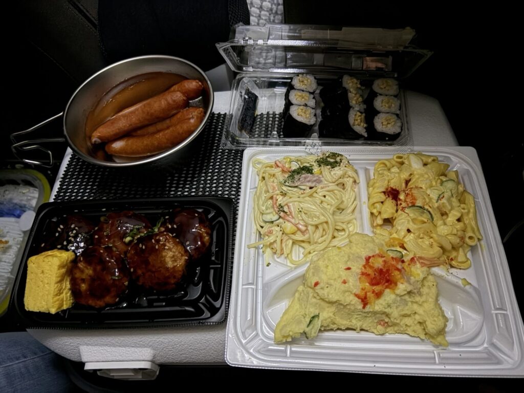 車内のテーブルに並べられたきんか豚ソーセージや惣菜