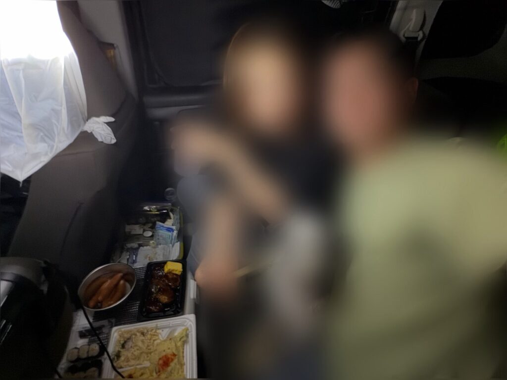 車内で愛犬と一緒にくつろぎながら食事をする夫婦
