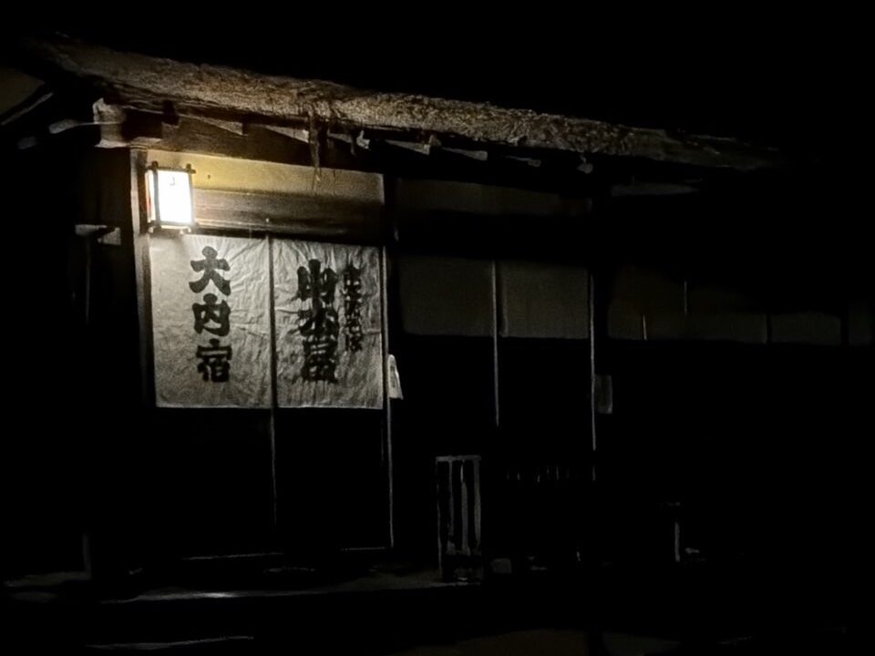 大内宿の文字が入った暖簾と軒先を照らす行灯の灯り