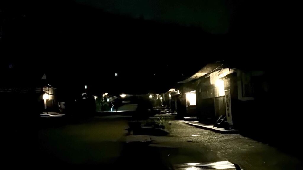 夜の大内宿のかやぶき屋根の家並みと通りを照らす柔らかな灯り
